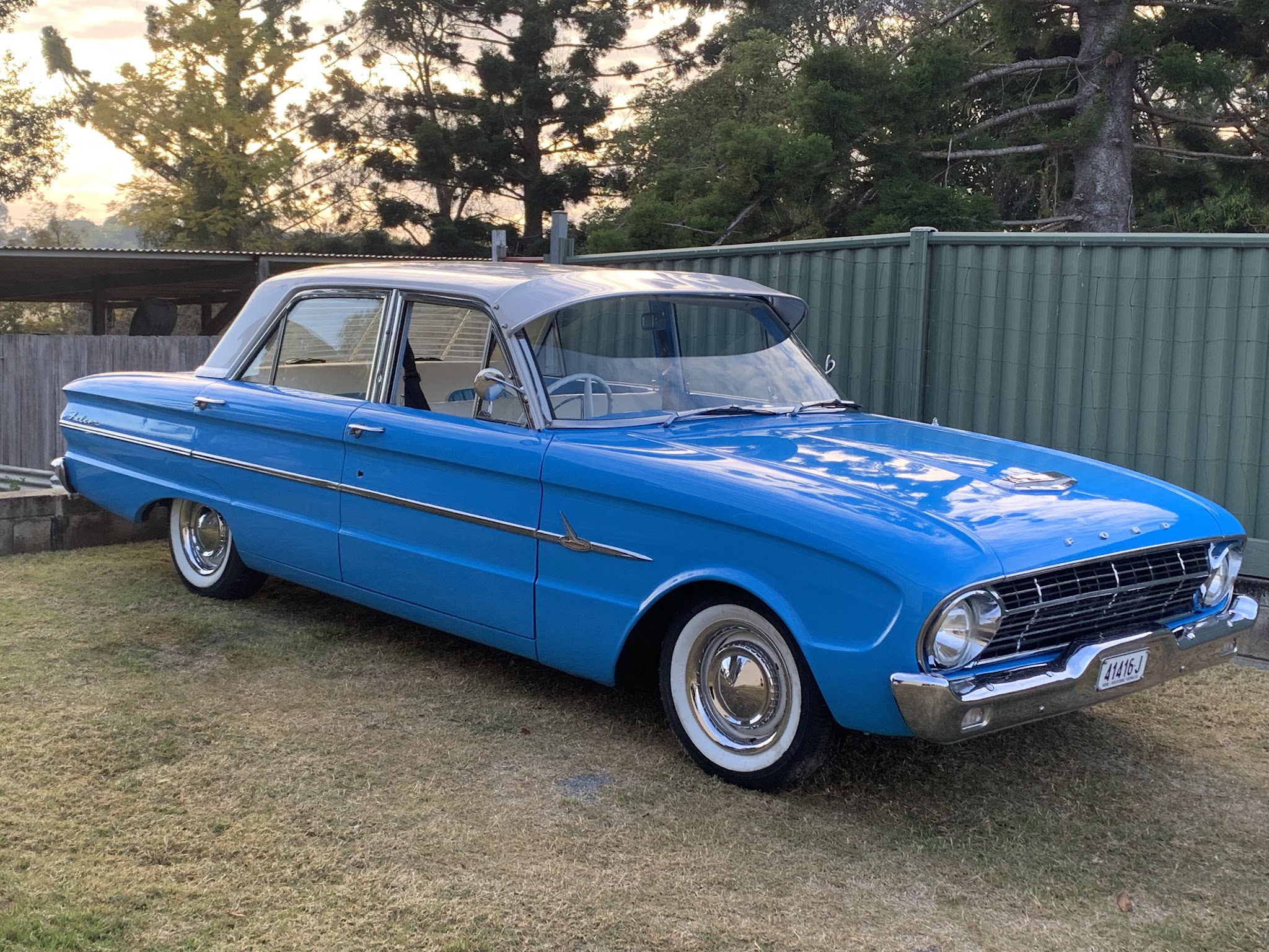 Blue and white early Ford Falcon sedan with whitewall tyres and chrome hubcaps